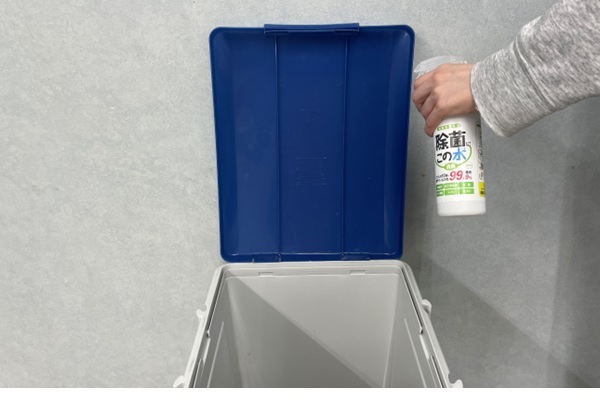 ゴミ箱のフタの裏に微酸性電解水をスプレーしている様子